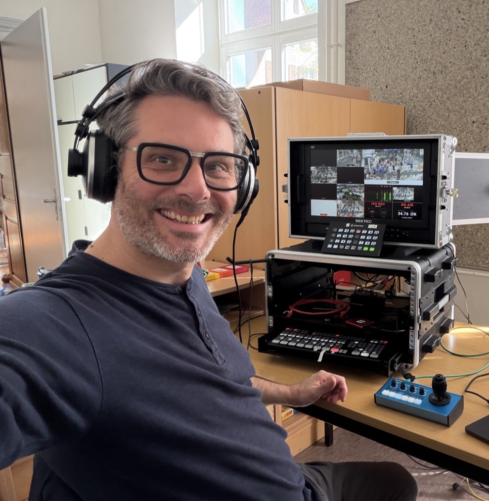Claus Pfisterer mit Headset an einem Live-Production-Setup
